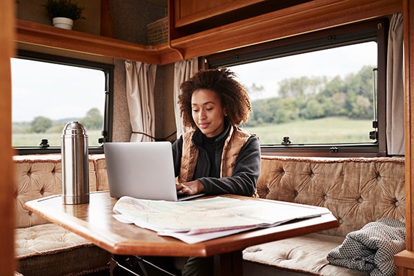 Woman working on laptop in camper